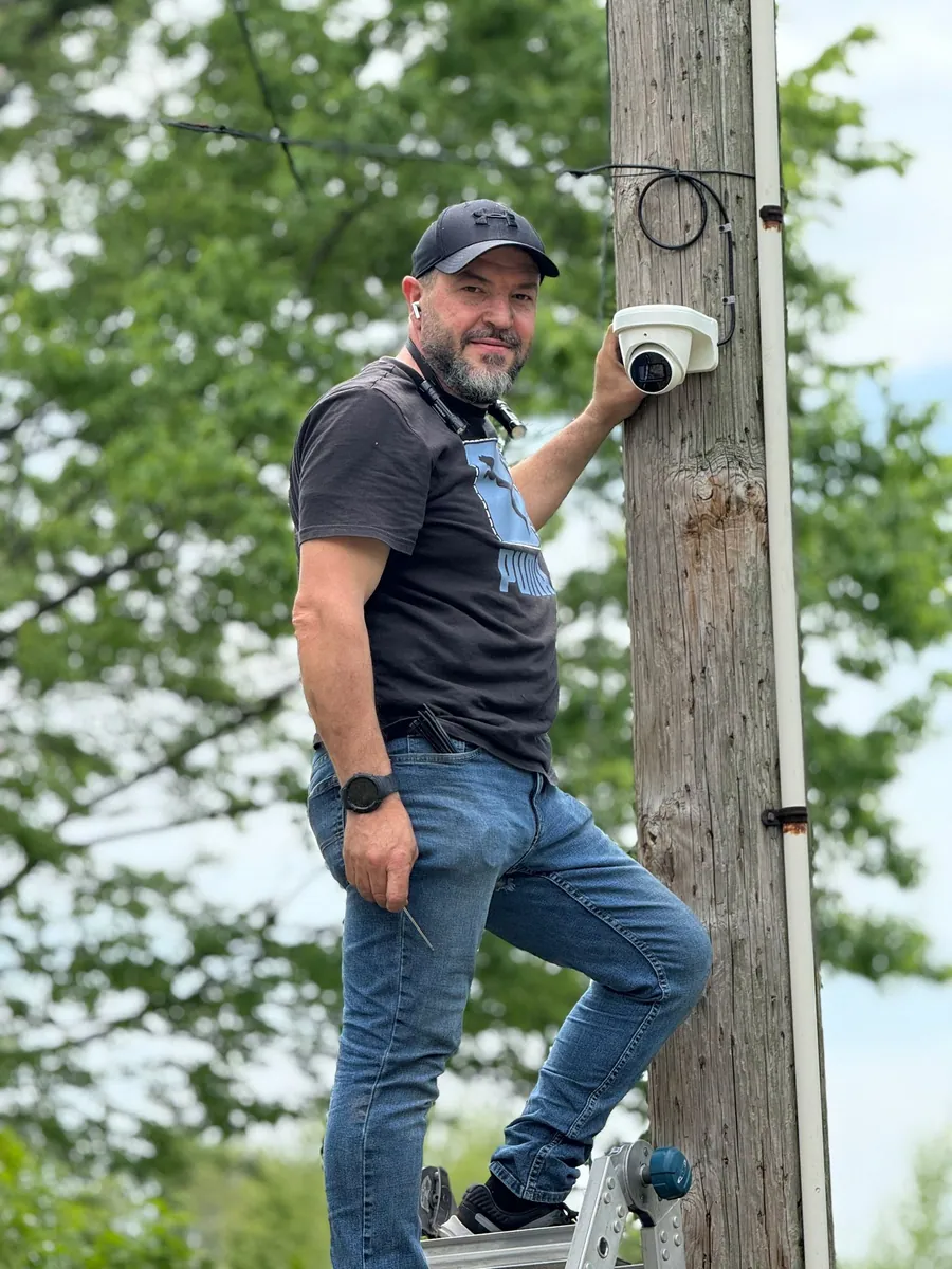 Technician mounting a camera on a utility pole